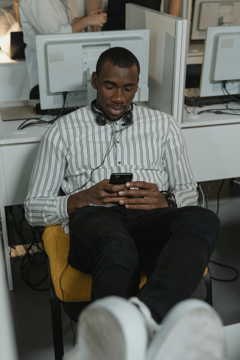 Man in White and Black Pinstripe Dress Shirt and Black Pants Sitting on Yellow Chair